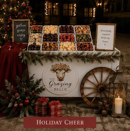 The Grazing Belle Holiday Cheer styled mobile cart with a Christmas tree, plaid gifts, and a glowing lantern
