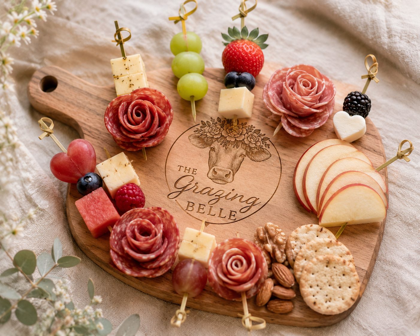 Heart-shaped grazing board with salami roses, fruit skewers, crackers, and nuts